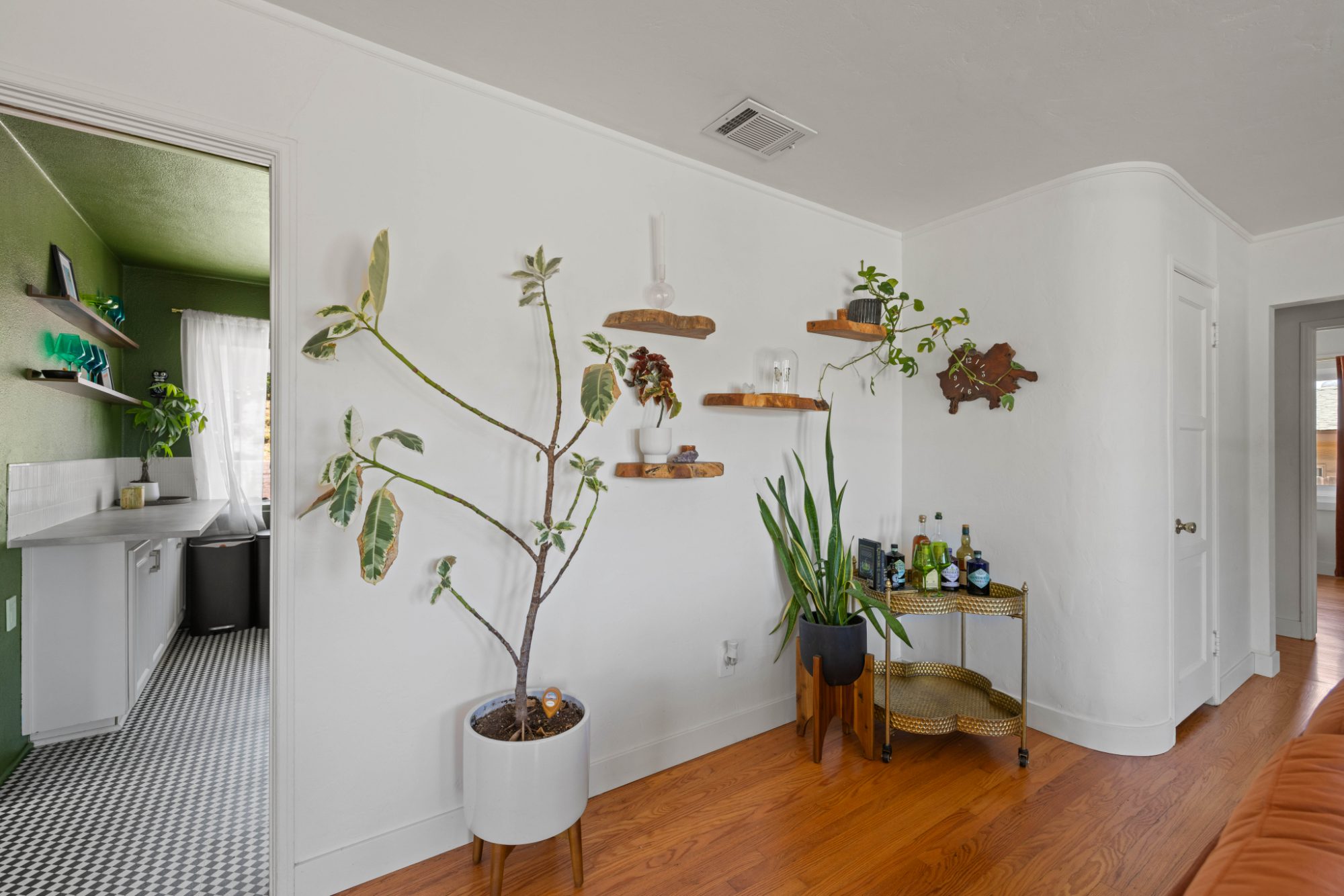 The bar-cart wall, kitchen beyond